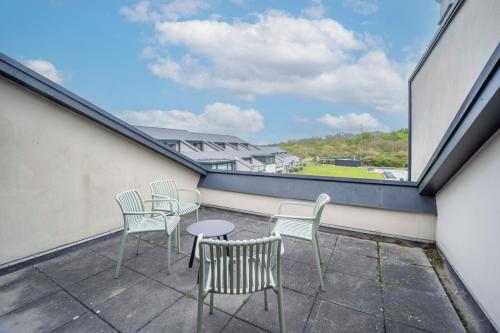 a balcony with chairs and a table and a window at Fletcher Zuiderduin Beachhotel in Westkapelle