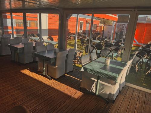 a restaurant with tables and chairs on a deck at Hôtel Acajou in Argelès-sur-Mer