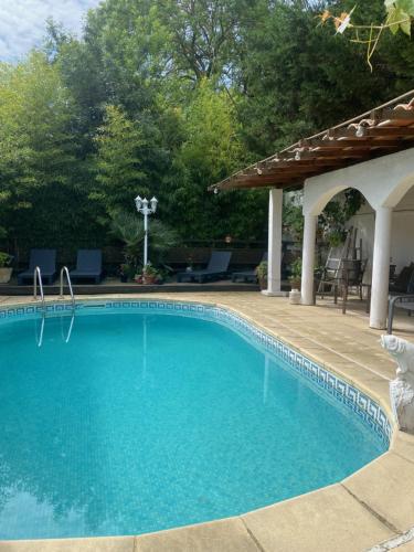 uma piscina com um gazebo e uma piscina em Maison d'hôtes Le Beauséjour em Carcassonne