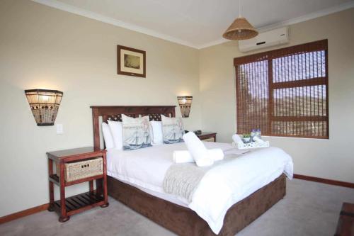 Schlafzimmer mit einem Bett mit weißer Bettwäsche und einem Fenster in der Unterkunft Royal Guest House in Port Alfred