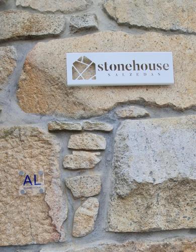 a sign on the side of a stone wall at Stone House in Salzedas