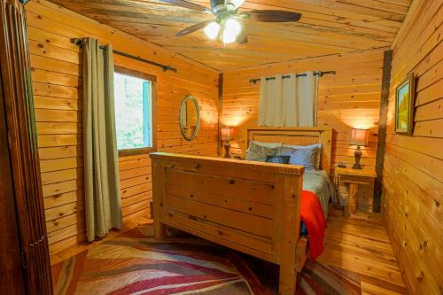 een slaapkamer met een bed in een blokhut bij The Big Little Cabin - Hot Tub & Playground in Dahlonega