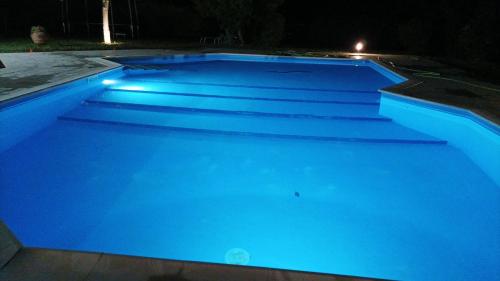 a swimming pool lit up in blue at night at casa stefano in Piumarola