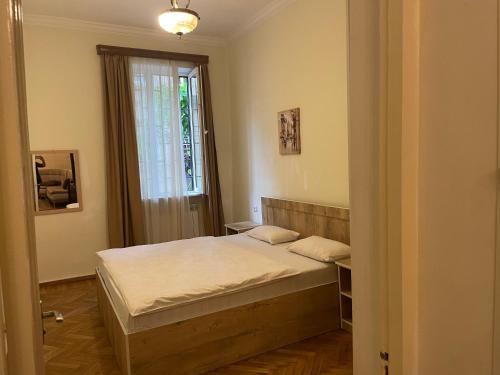 um pequeno quarto com uma cama e uma janela em vake em Tbilisi