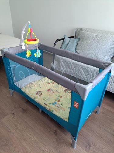 a blue and gray bunk bed with a baby crib at Lauku Str.Apartment in Liepāja