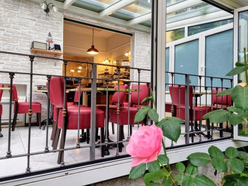 um quarto com uma varanda com cadeiras vermelhas e uma mesa em Hotel Charly em Milão