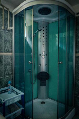 a shower in a bathroom with green walls at Chalupa KLÁRA -Liptov in Ružomberok