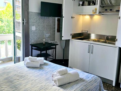 una pequeña cocina con 2 toallas en una cama en House LeoMar di Sara, en Génova