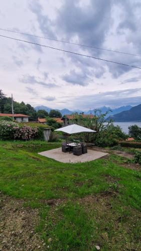 a picnic table in a field with a view of the water at villetta con giardino privato in Cremia