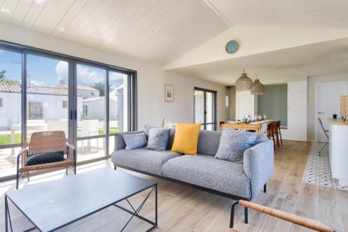 un salon avec un canapé et une table dans l'établissement maison neuve- 6 adultes & 4 enfants - 350m plage, à Noirmoutier-en-l'lle
