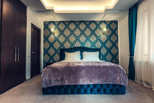 a bedroom with a large bed with a blue headboard at Villa Tom in Sinaia