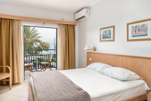 um quarto com uma cama e uma varanda em Danae Hotel em Egina