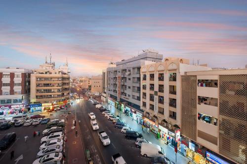 a city street with parked cars in a city at Naif Palace Hotel in Dubai