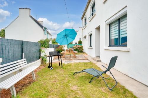a patio with a table and a chair and an umbrella at Maison pour 6, port et plage de Lesconil in Plobannalec-Lesconil
