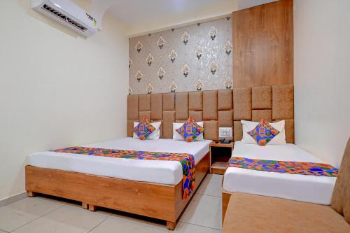 a bedroom with two beds and a wall at FabExpress SK Prime in Ujjain