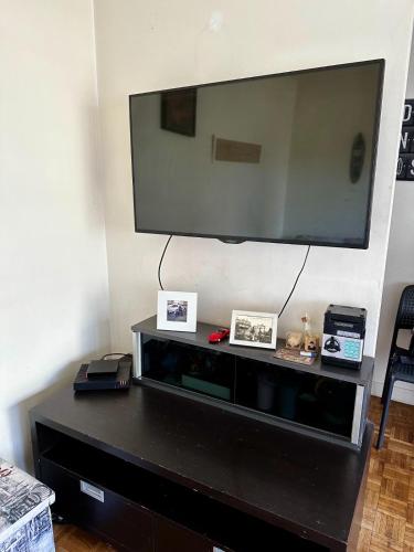 - un centre de divertissement noir avec une grande télévision murale dans l'établissement Sweet Home Montrouge, à Montrouge