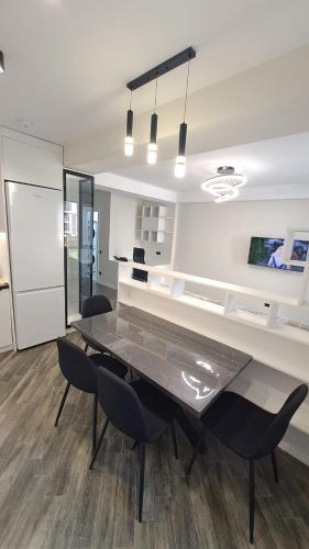 a dining room with a glass table and chairs at AIRPORT&APARTMENT&parking in Chişinău