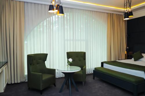 a hotel room with a bed and a table and chairs at Dondar Hotel Formula 1 View in Baku