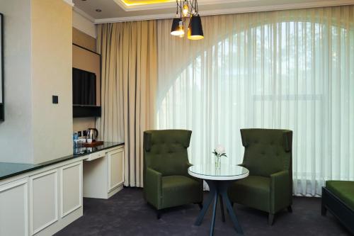 a living room with a table and two chairs at Dondar Hotel Formula 1 View in Baku