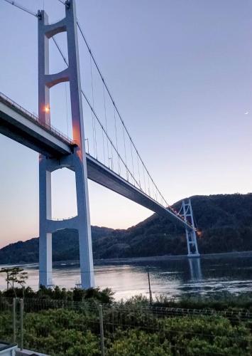 a bridge over a river next to a river at nagi-setouchi in Kure