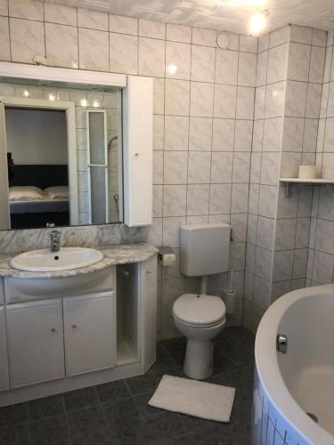 łazienka z toaletą, umywalką i wanną w obiekcie Hotel Weismann w mieście St. Georgen im Attergau