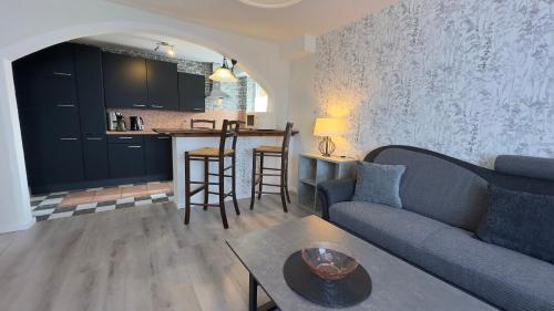 ein Wohnzimmer mit einem Sofa und einem Tisch sowie eine Küche in der Unterkunft Hotel Wernerwald in Cuxhaven