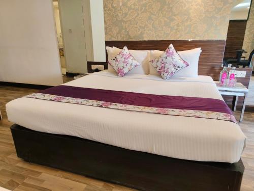 a large bed with pink and purple pillows on it at Regenta Place Bangalore, Cunningham Road in Bengaluru