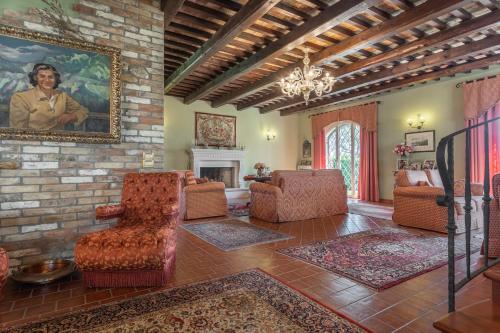 a living room with chairs and a painting on the wall at La Betulla - Ocean-Mountain View LUX in Montone