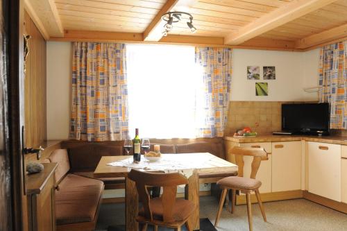 eine Küche und ein Wohnzimmer mit einem Tisch und einem Sofa in der Unterkunft Charlys Ferienwohnung in Samnaun