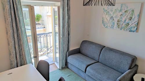 d'un salon avec un canapé et un balcon. dans l'établissement Lamartine hypercentre 511, à Nice