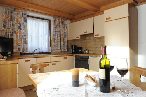 a kitchen with a table with a bottle of wine at Charlys Ferienwohnung in Samnaun