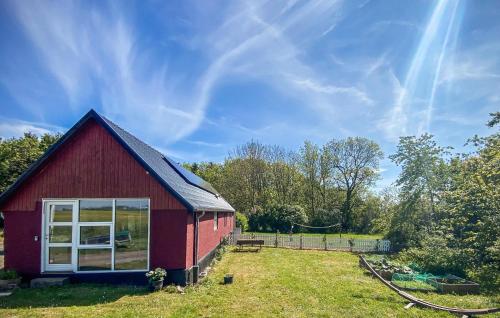 a red barn with a window on a field at 1 Bedroom Amazing Apartment In Rønne in Rønne