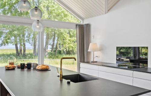 a kitchen with a sink and a large window at 4 Bedroom Nice Home In Strøby in Strøby