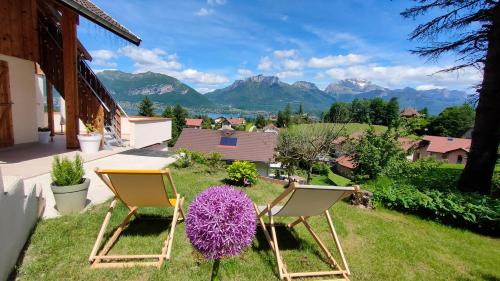 two chairs on a lawn with mountains in the background at VUE LAC LODGES in Sévrier