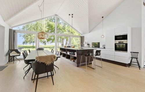 a kitchen and dining room with a table and chairs at 4 Bedroom Nice Home In Strøby in Strøby
