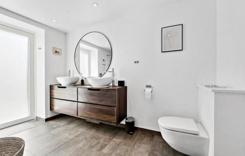 a bathroom with a sink and a mirror on a dresser at 4 Bedroom Nice Home In Strøby in Strøby