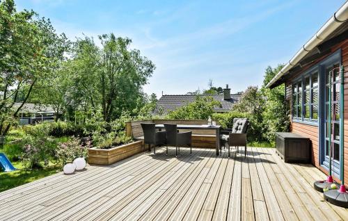 a wooden deck with a table and chairs on it at Cozy Home In Korsør With Kitchen in Korsør