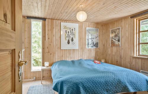 um quarto com uma cama azul e uma janela em Cozy Home In Korsr With Kitchen em Korsor