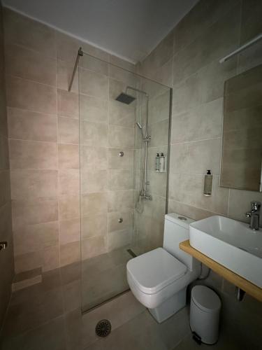 y baño con ducha, aseo y lavamanos. en ILENA HOTEL en Acharavi