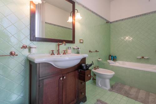 a bathroom with a sink and a toilet and a mirror at La Betulla - Ocean-Mountain View LUX in Montone