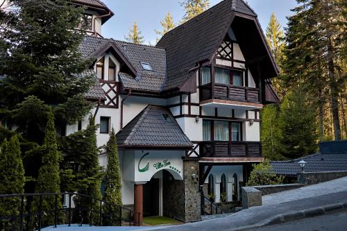a large white house with a black roof at Villa Tom in Sinaia