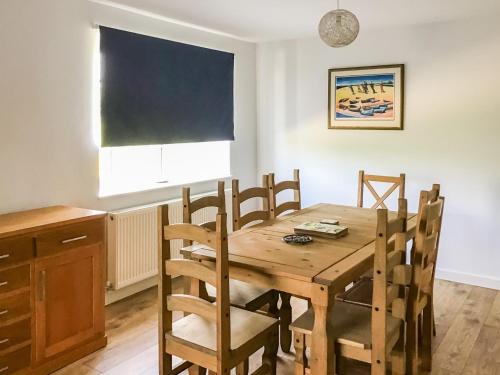 a dining room with a wooden table and chairs at Hempstead End in Lessingham