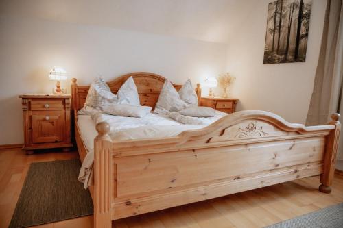 um quarto com uma cama de madeira com almofadas em Ferienwohnungen Baumann-Breitenberg em Sankt Georgen am Reith
