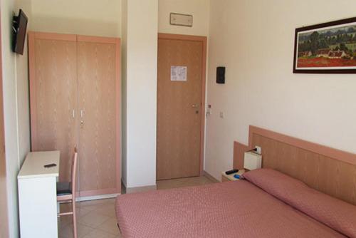 a bedroom with a bed with a pink blanket at B&B Hotel Fattoriamare in Alba Adriatica