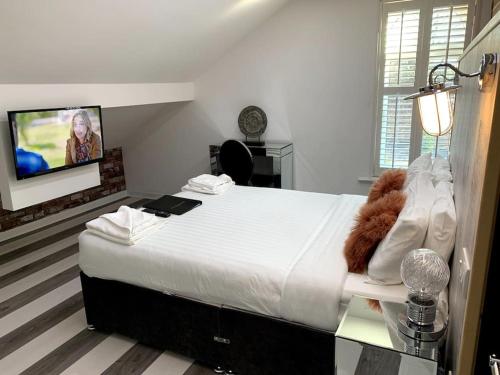 a bedroom with a large bed with a tv on the wall at Ivy Mount Boutique in Manchester
