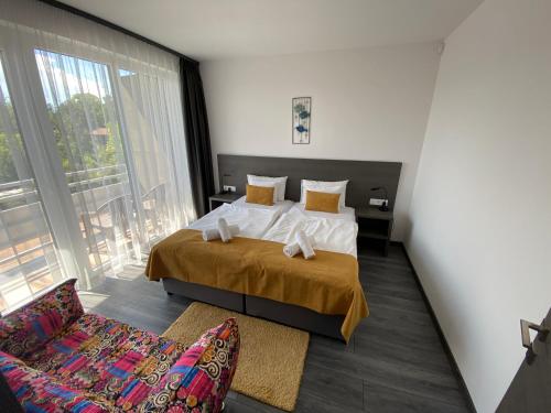 HOTEL CSOPAK Resort & Lake في تشوباك: غرفة نوم بسرير ونافذة كبيرة