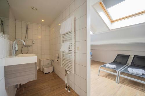 a bathroom with a bed and a sink in a room at Fletcher Zuiderduin Beachhotel in Westkapelle