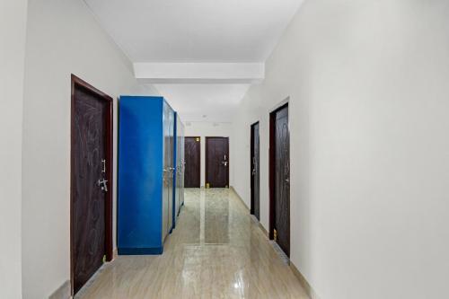 un couloir avec des murs et des portes bleus et blancs dans l'établissement OYO Hotel Grand Eden, à Kolkata