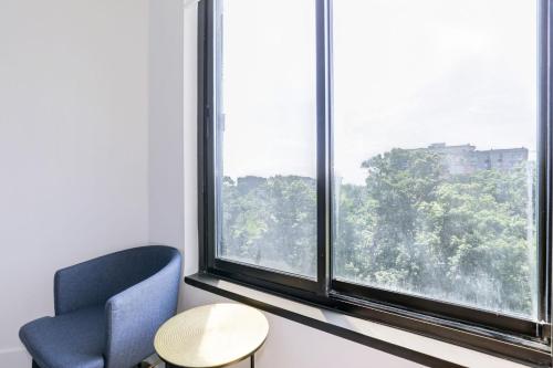 a room with a blue chair and a window at 2BR Executive Apartment in Prime Location in Arlington