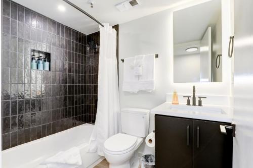 a bathroom with a toilet and a sink and a shower at 2BR Executive Apartment in Prime Location in Arlington
